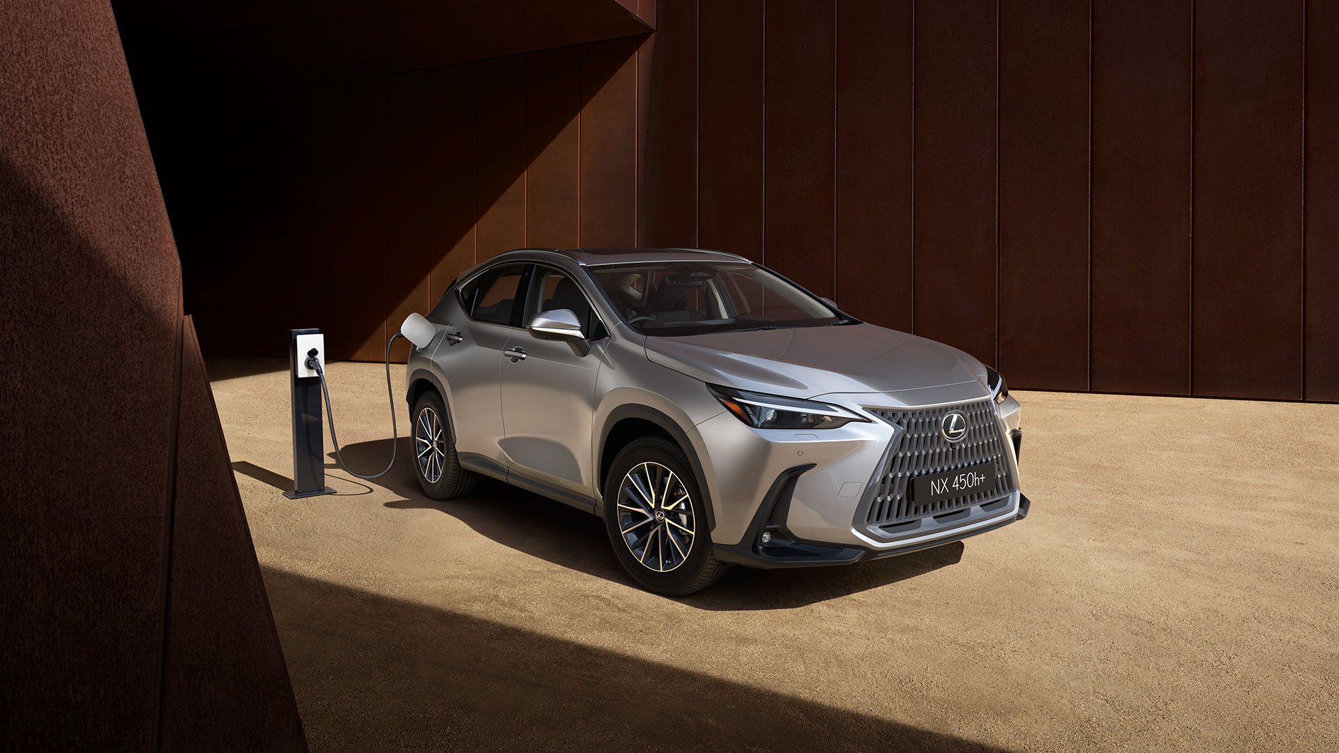 Lexus NX 450h+ charging on a gravel driveway