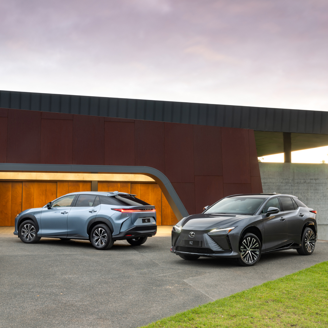 Light blue and dark grey Lexus RZ sitting parked on a concrete driveway.