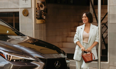 Lexus Brand Ambassador Melissa Leong stands beside dark grey Lexus LX SUV on a city street.