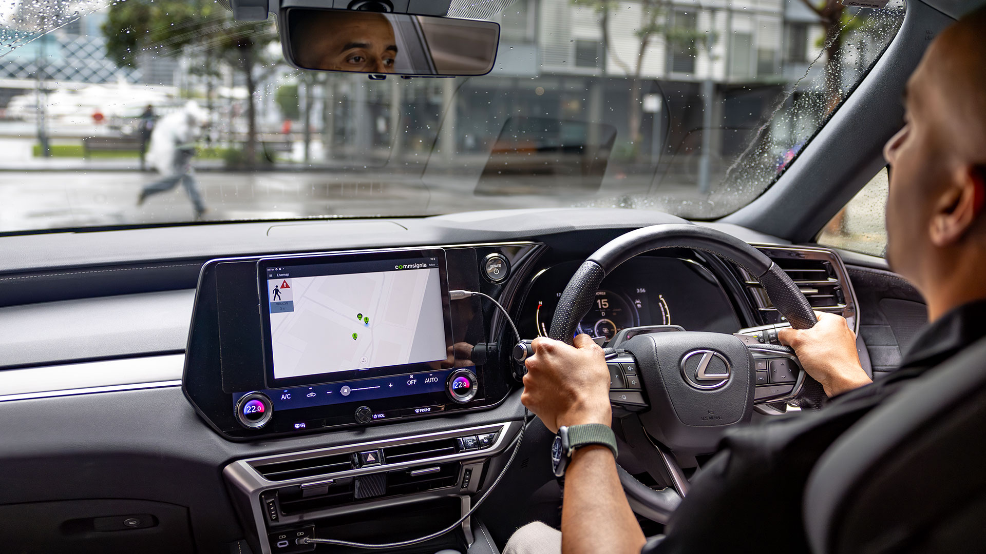 A man drives a Lexus vehicle through a city