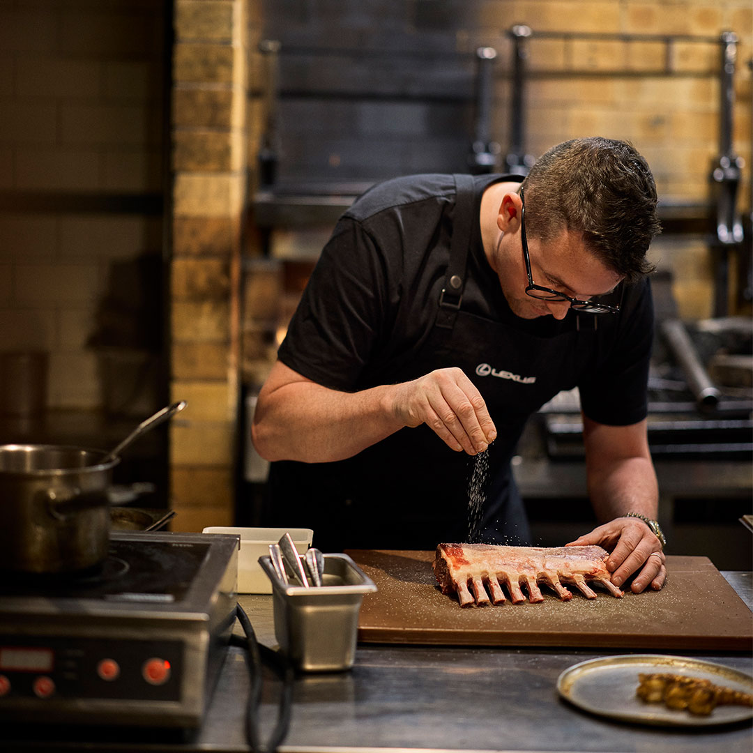 A chef prepares a rack of lamb