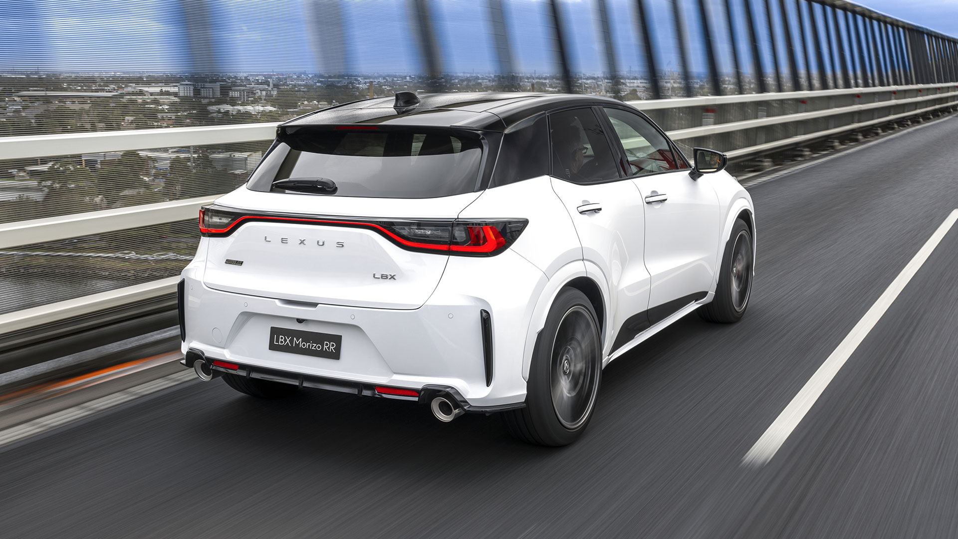 A white Lexus LBX Morizo RR driving over a bridge