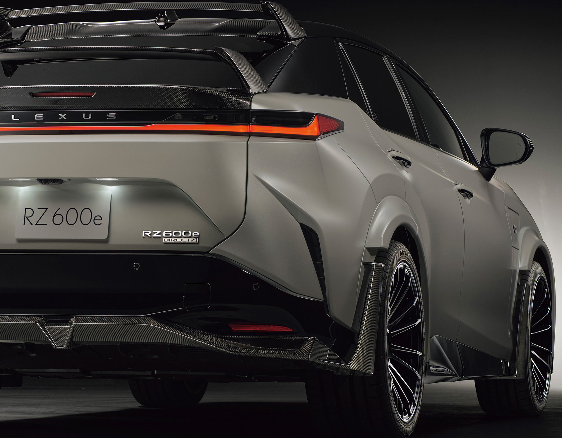 Rear view of a white Lexus RZ 600e F Sport Performance in a studio setting